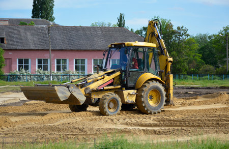 yellow tractor levels the sand at the construction siteの写真素材