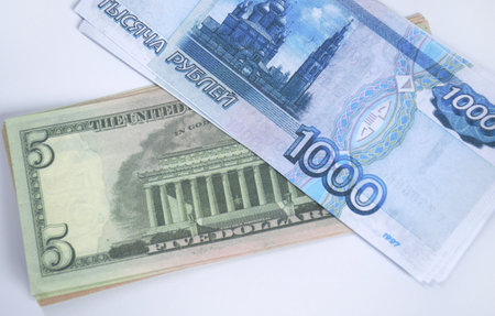 Russian rubles and American dollars stacked in bundles on a white background. the struggle of the economy in the face of severe sanctions, inflation and economic crisisの写真素材