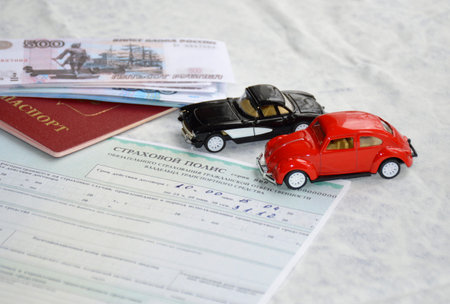 A form of car insurance, next to it lies a passport of a Russian citizen, a pack of Russian rubles...