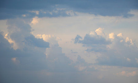 beautiful fluffy clouds are illuminated with orange light during sunset or sunrise. beauty in nature. the sun's rays paint both the sky and clouds with bright colorsの写真素材