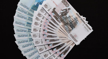 Russian rubles of different denominations are fanned out on a black background. transition of trade to settlements in the national currency. business and economic support. resilience during sanctionsの写真素材