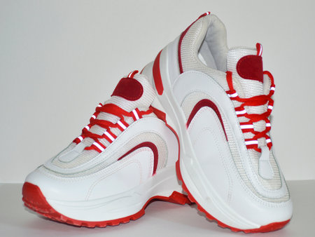 women's sneakers in red and white on a white background. Sports shoes. Casual shoes for sports and walking. youth style. Shoes for fitness, running, yogaの写真素材