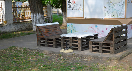 table and chairs made of wooden pallets near a closed street cafe. place for fast food and drinks. rest and relaxation in the fresh airの写真素材