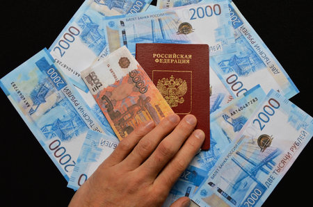 passport of a Russian citizen and 5000 banknotes on the background of Russian rubles. travel abroad, payment for services and goods. fight against corruption and bribesの写真素材
