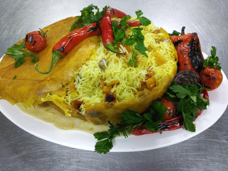 pilaf with beef baked in pita bread on a large plate. served with grilled vegetables, hot peppers...