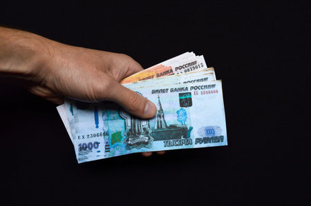a pack of Russian rubles in a man's hand. fight against bribes, corruption and fraudsters. money for...