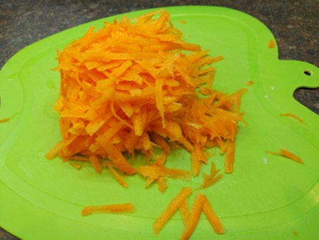 gratified fresh carrots on a green board. ingredient for vegetable salad. tasty, healthy and healthy food for children and adults. vegetables rich in vitamins and caroteneの写真素材