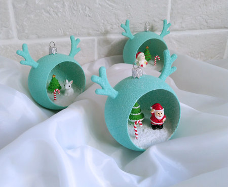 New Year's toys in the form of a ball with horns with small miniatures inside. decorative gift balloons to decorate your home, office or as a gift. Christmas tree, Santa Claus, snowman and hareの写真素材