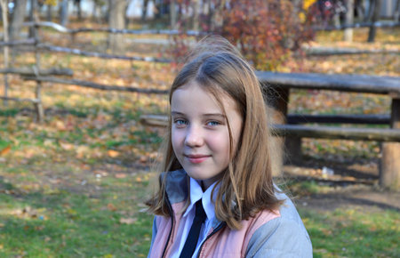 portrait of a beautiful girl while walking in the autumn park, the child is smiling. walks in the...