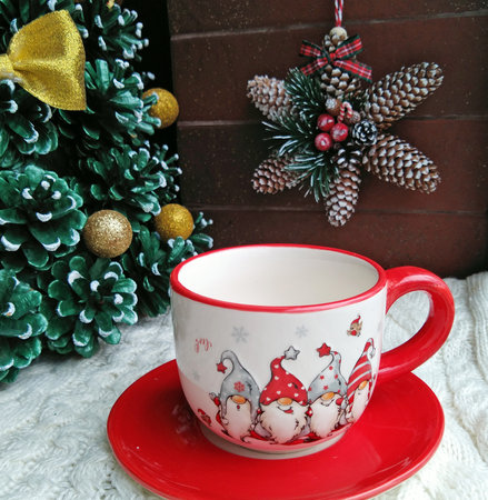 beautiful Christmas cup for a hot drink on a background of pine and fir cones. celebrating new year and christmas. home decorの写真素材