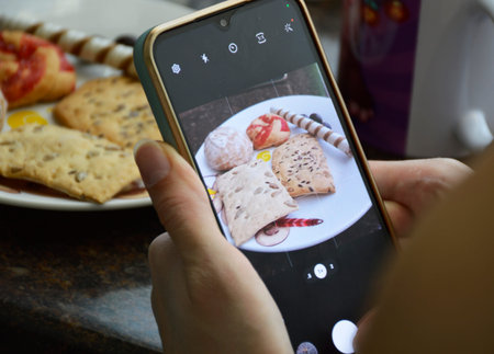 female hands holding smartphone and taking photo of sweet food. photo or video blogger. sweet and...