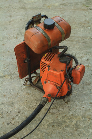 Used lawn mower sits on the concrete patio of a house ready to be used to mow the lawn