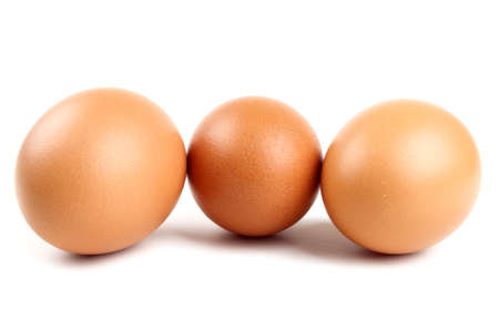 three eggs in a carton on a white backgroundの写真素材