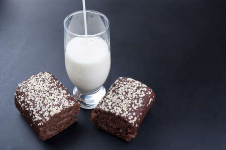 chocolate roll and a glass of milk on a black backgroundの写真素材