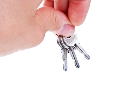 three silver keys in a hand isolated on white background