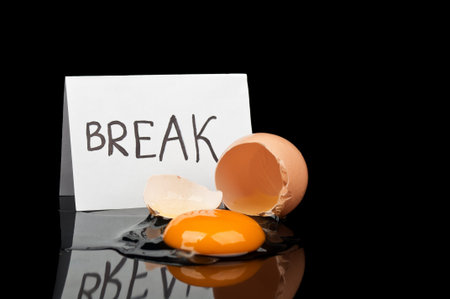Break Time and broken egg isolated on a black background