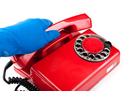 man in blue gloves picked it up the red phone isolated on a white backgroundの写真素材