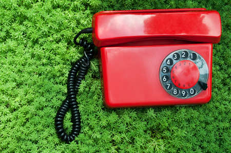 retro telephone on a green grass backgroundの写真素材