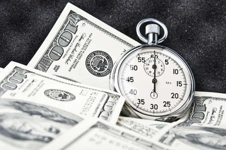 stopwatch in the case with dollars backgroundの写真素材