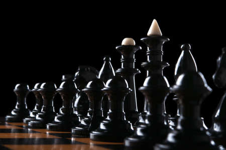 black chess pieces on the board isolated on a black backgroundの写真素材