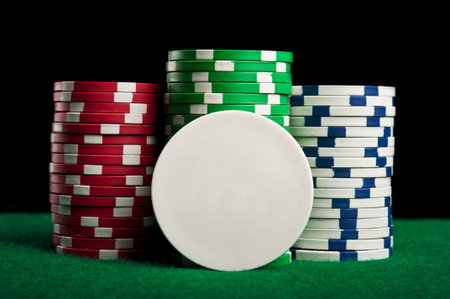 poker chips on green table on a black background