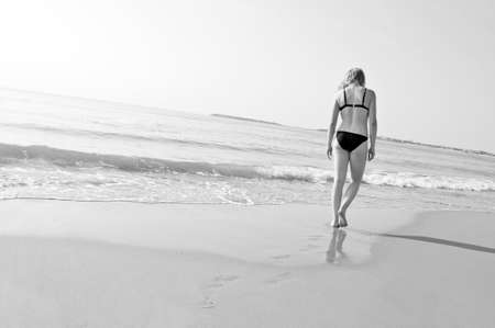 lonely young girl walks on the beachの写真素材