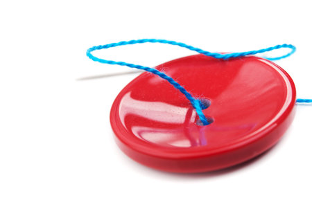 red button and blue thread isolated on white background