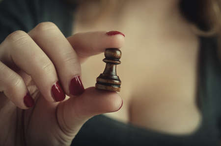 sexy woman playing chess and hold pawnの写真素材