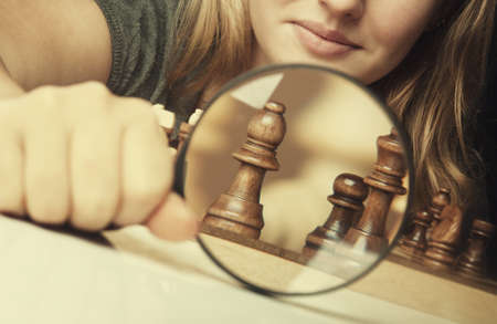 woman play chess and hold loupe backgroundの写真素材