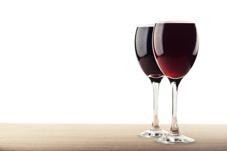 red wine into glass isolated on white backgroundの写真素材