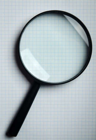 Magnifying glass and notebook on backgroundの写真素材