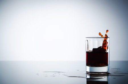 splash in brandy glass on background