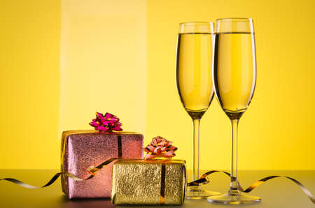 glasses of champagne and gift on backgroundの写真素材