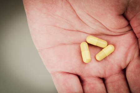 three yellow pills on handの写真素材