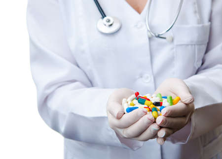doctor holding colorful pills in hand. isolated on whiteの写真素材