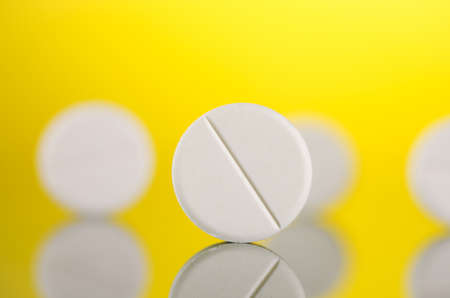 closeup of medical tablets on yellow backgroundの写真素材