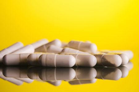 white capsule on glass yellow background
