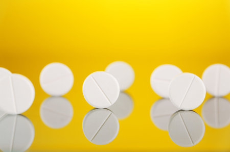 closeup of tablets on yellow backgroundの写真素材