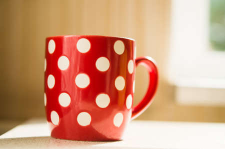 red coffee cup on kitchen tableの写真素材