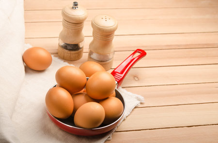 eggs on pan at wooden tableの写真素材