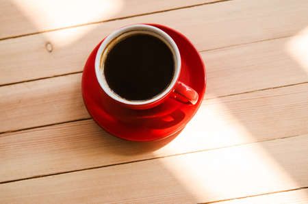 red cup of coffee on wooden tableの写真素材