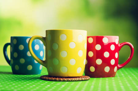 colored coffee cups on kitchen tableの写真素材