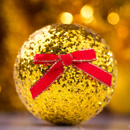 Christmas ball on golden bokeh backgroundの写真素材