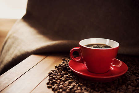 red cup of coffee with roasted beansの写真素材