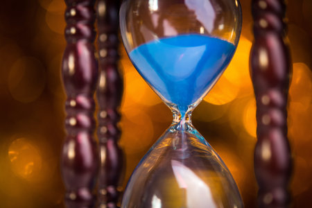 hourglass clock on light bokeh background