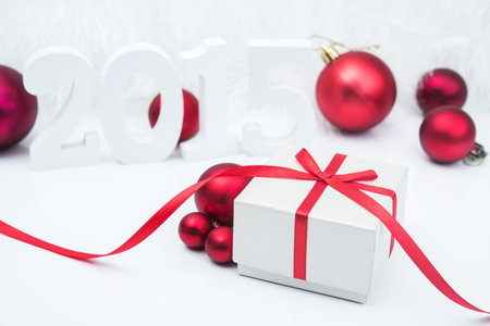 Red box gift with ribbon and balls. Christmas background.