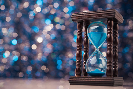 Wooden hourglass clock on abstract background