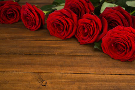 Red roses on wooden table. Valentine day background.の写真素材