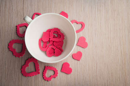Romantic white cup with red hearts on backgroundの写真素材