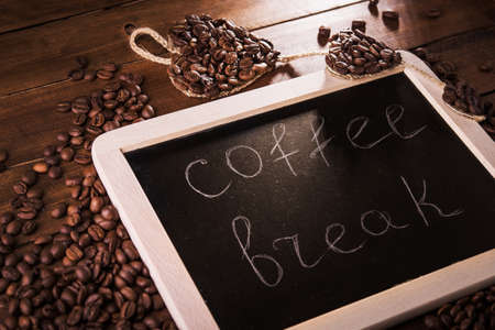 Coffee break board with grains on wood tableの写真素材